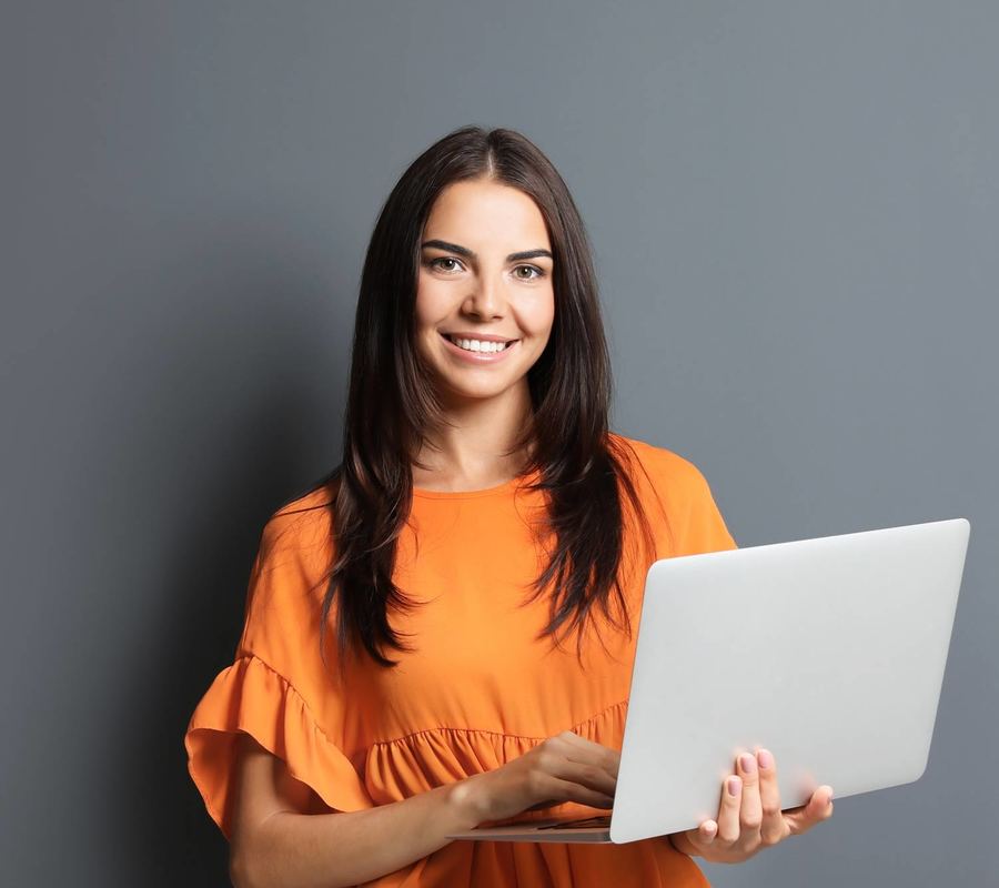 Orange Top Dark Hair Smiling Woman Working Computer